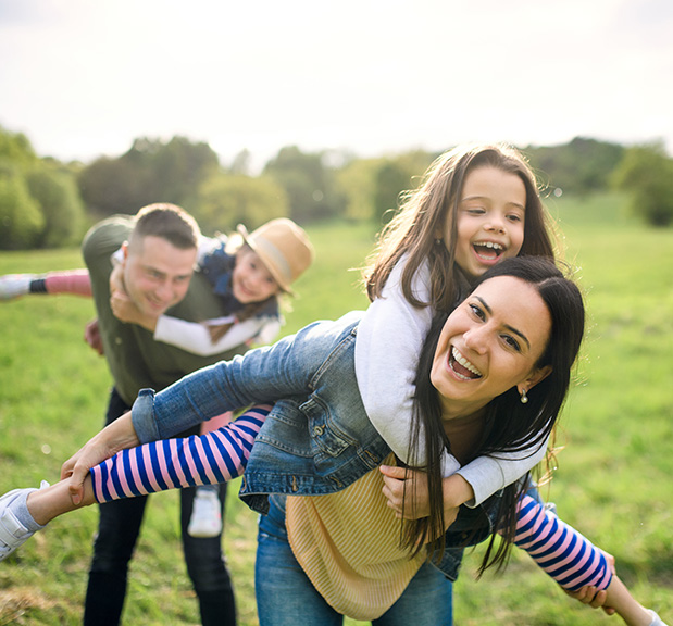 Happy family with two small daughters having fun outdoors in spring nature.